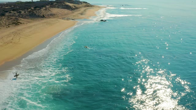 SHIPWRECKS LOS CABOS BCS MEXICO-2021: Surfers Waiting in Ocean Waves near Sandy Beach