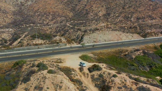 MARQUIS LOS CABOS MEXICO-2021: Vehicles Traveling on Desert Highway with Mountain Backdrop