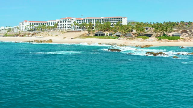 MARQUIS LOS CABOS MEXICO-2021: Waves Breaking on Rocky Shore with Coastal Building