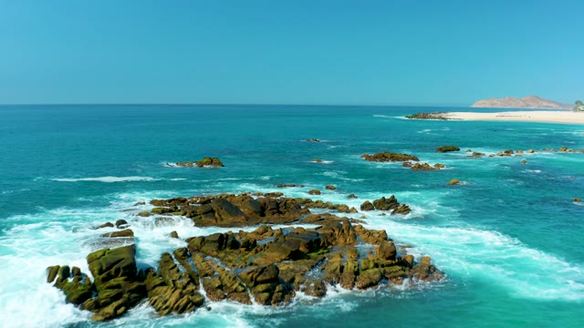 MARQUIS LOS CABOS MEXICO-2021: Waves Crashing on Rocky Shore with Sandy Beach