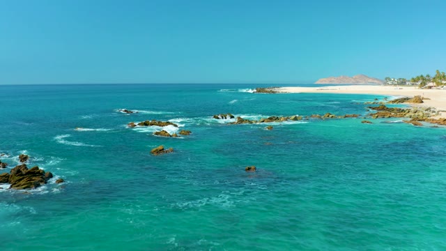 MARQUIS LOS CABOS MEXICO-2021: Turquoise Ocean Waves Crashing on Coastal Rocks