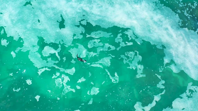 MARQUIS LOS CABOS MEXICO-2021: Surfer Paddling Through Foamy Ocean Water