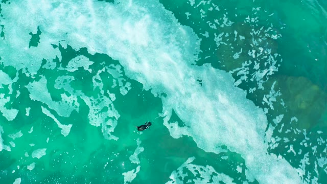 MARQUIS LOS CABOS MEXICO-2021: Surfer Navigating Turquoise Ocean Waves
