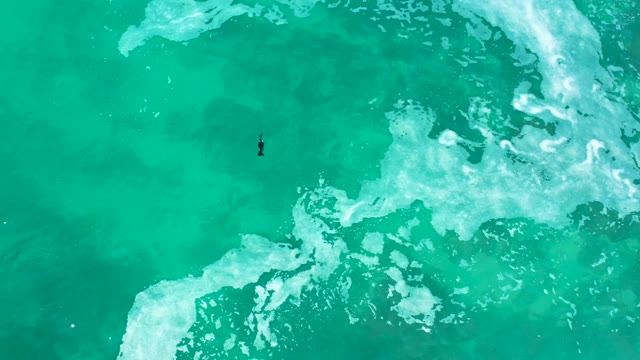 MARQUIS LOS CABOS MEXICO-2021: Surfer Moving Through Turquoise Ocean Waves