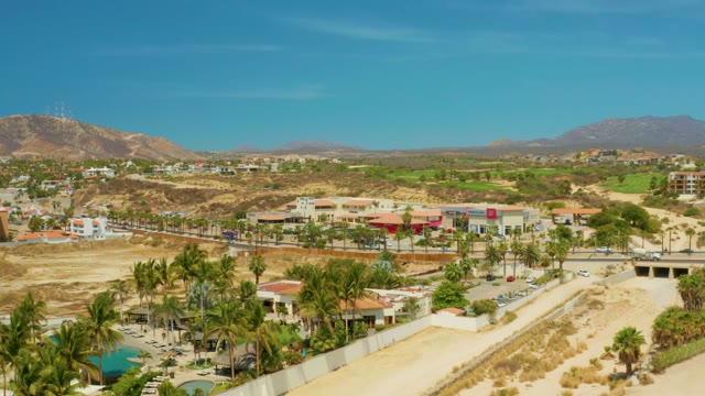 CAMPESTRE SAN JOSE DEL CABO BCS MEXICO-2021: Dry Riverbed with Suburban Buildings and Distant Mountains