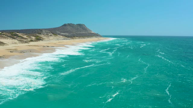 LA LAGUNA BEACH LOS CABOS MEXICO-2021: Ocean Waves Rolling Onto Sandy Beach