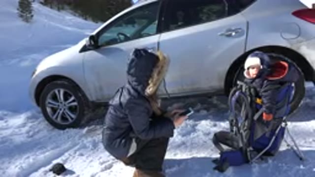 CRESTED BUTTE COLORADO-2015: Taking A Picture Of A Young Child In A Backpack In Snow