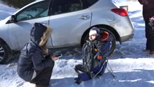 CRESTED BUTTE COLORADO-2015: Family Recording Their Child Outside The House In Snow