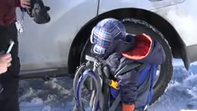 CRESTED BUTTE COLORADO-2015: Baby Boy in Carrier Stares at Mother on Snowy Day