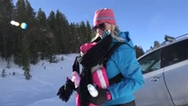 CRESTED BUTTE COLORADO-2015: Mother Holding Child In A Carrier While Dressed In Winter Clothes