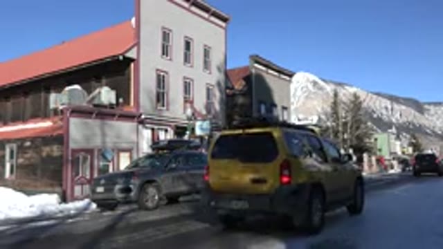 CRESTED BUTTE COLORADO-2015: Cars Driving Down The Road In A Town While It Is Snowy