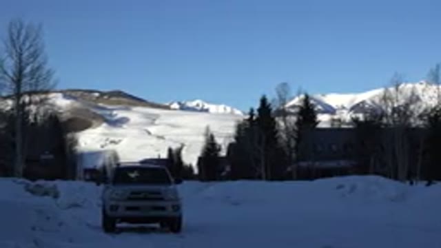 CRESTED BUTTE COLORADO-2015: Snowy Mountainside With A Small Building And A Car
