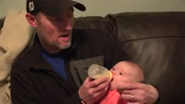 WESTMINSTER COLORADO-2015: A Man Sitting On A Brown Sofa Holding A Baby