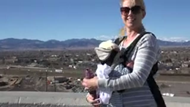 WESTMINSTER COLORADO-2015: Blonde Woman Holding Baby On A Windy Day With Highway