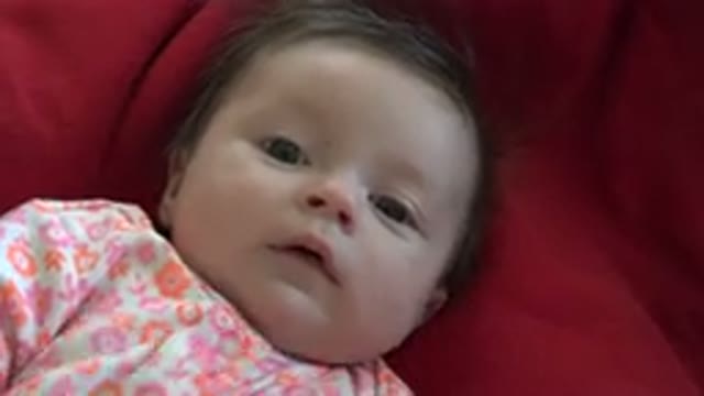 WESTMINSTER COLORADO-2015: Baby Wearing Red and White Sleeper Lies on Red Blanket