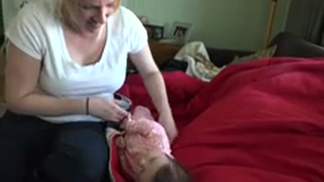 WESTMINSTER COLORADO-2015: Woman Wearing White Shirt Picks Up Baby Wearing Pink