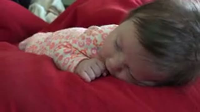WESTMINSTER COLORADO-2015: A Young Baby Crawls or Squirms on a Red Blanket