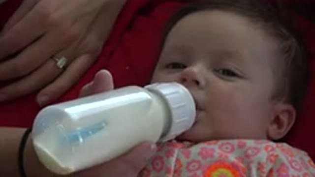 WESTMINSTER COLORADO-2015: Little Girl With Flowery Clothes Sucking Milk From Bottle