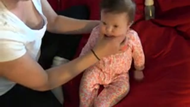 WESTMINSTER COLORADO-2015: Woman Sitting On The Bed Taking Care Of A Baby Lying