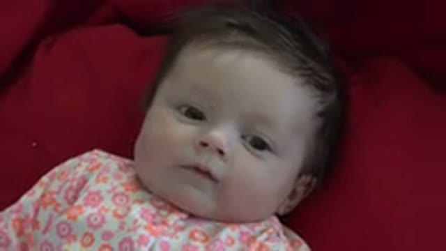 WESTMINSTER COLORADO-2015: Baby in Flowery Clothes Lying on a Red Blanket