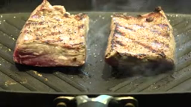WESTMINSTER COLORADO-2015: Steak Or Fish Being Cooked On A Grill Stove Top