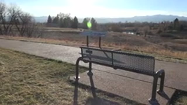 ARVADA COLORADO-2015: Panning Shot Of Footpath And Park With Bench And Info Board