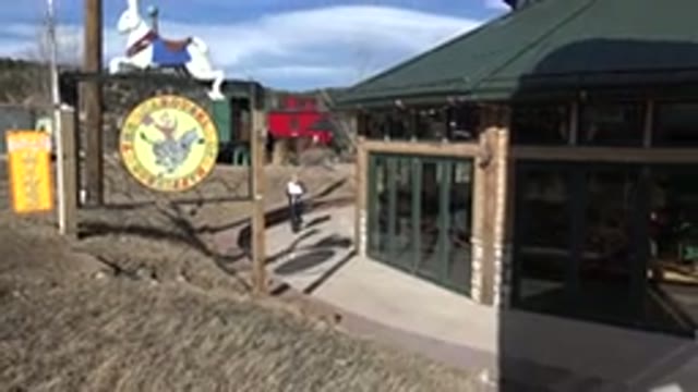 NEDERLAND COLORADO-2015: Person Wearing Black Pants Knocks On Door Of Green Building