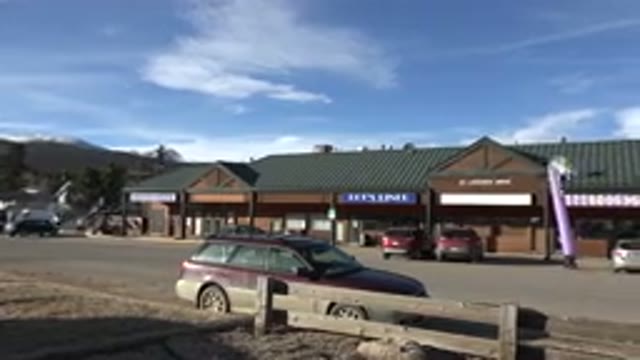 NEDERLAND COLORADO-2015: Parking Lot With A Few Cars And A Pink Inflatable Man