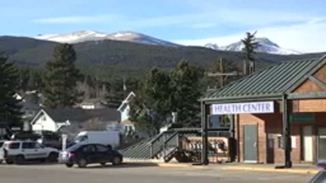 NEDERLAND COLORADO-2015: Green Area With Trees Parked Cars And People Walking