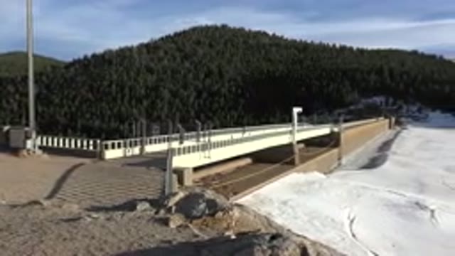 NEDERLAND COLORADO-2015: A Scene Of A Bridge Next To Some Snow And A Mountain In