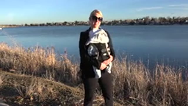WESTMINSTER COLORADO-2015: Woman Wearing Sunglasses Bouncing Her Baby Beside A