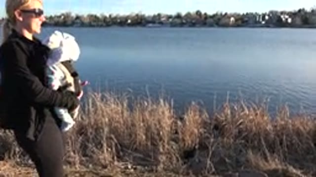 WESTMINSTER COLORADO-2015: A Woman By A Lake Carrying Her Infant With