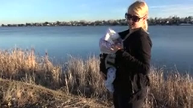 WESTMINSTER COLORADO-2015: Mother Rocking Baby While Standing By The Lake Shore