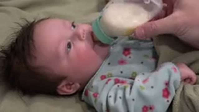 WESTMINSTER COLORADO-2015: Baby Laying Down On A Surface Drinking A Bottle