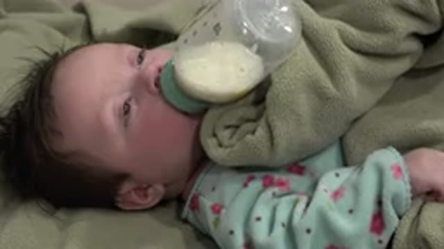 WESTMINSTER COLORADO-2015: Sleepy Baby In Blue Pajamas Drinking Milk From A Bottle