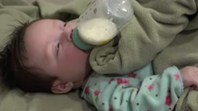 WESTMINSTER COLORADO-2015: Baby Wearing Blue Sleeper Sleeps Under Green Blanket