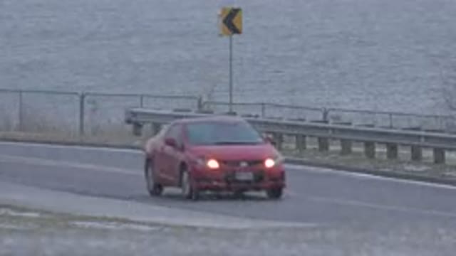 WESTMINSTER COLORADO-2015: A Red Car Passing Through a Bridge in Windy Weather