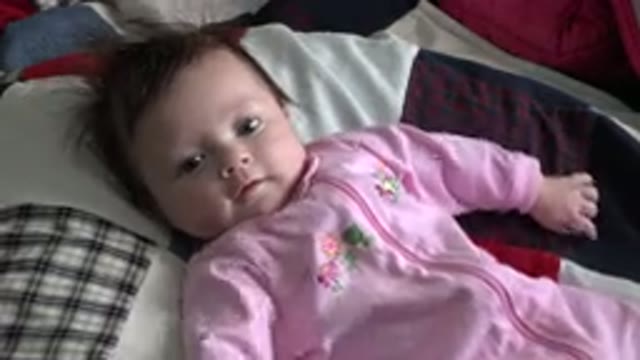 WESTMINSTER COLORADO-2015: Infant Wearing Pink Sleeper Lies On Patchwork Quilt