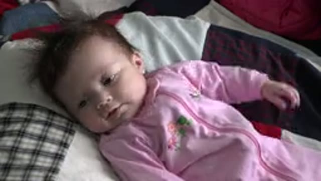 WESTMINSTER COLORADO-2015: Baby Girl Laying On A Bed Staring At The Camera