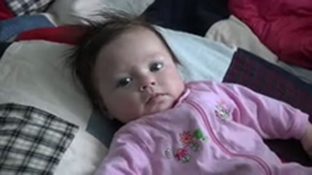 WESTMINSTER COLORADO-2015: Baby Wearing Pink Pajamas Lying On A Cushion And Moving Arms