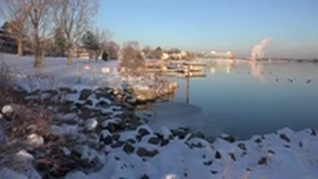 WESTMINSTER COLORADO-2015: The Snow Covered Ground Surrounds The Lake On A Bright Winter Day