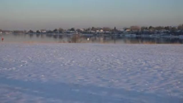 WESTMINSTER COLORADO-2015: Man Playing In The Snow Near A Frozen Lake During A Sunny Winter Day