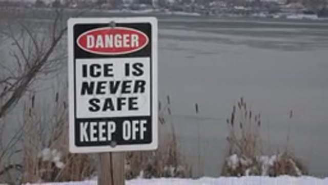 WESTMINSTER COLORADO-2015: Red Black And White Danger Sign Near Frozen Pond On A Cloudy Day