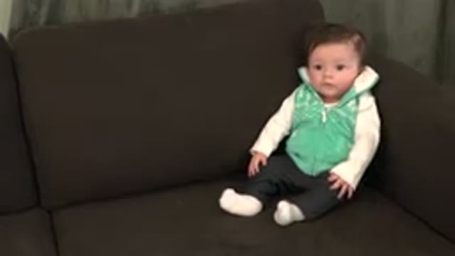 WESTMINSTER COLORADO-2015: Female Baby Sitting On Brown Couch Talking And Fidgeting