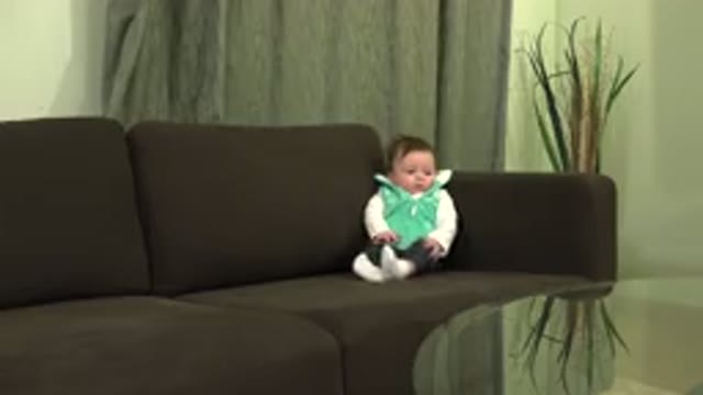 WESTMINSTER COLORADO-2015: A Baby in Green and Black Dress Sitting on Brown Sofa