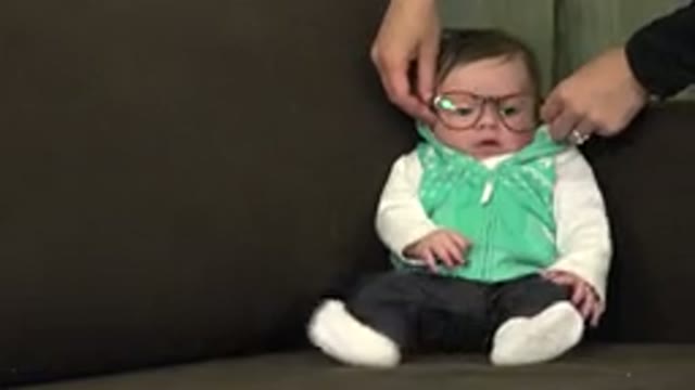 WESTMINSTER COLORADO-2015: Infant Wearing Green and White Vest with Glasses Sits on Sofa