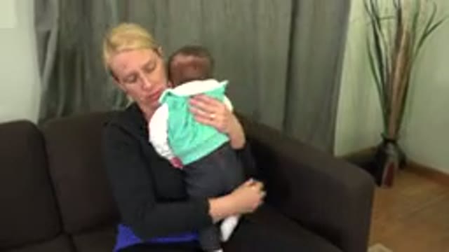 WESTMINSTER COLORADO-2015: Blonde Mother Sitting With Baby in Arms Patting