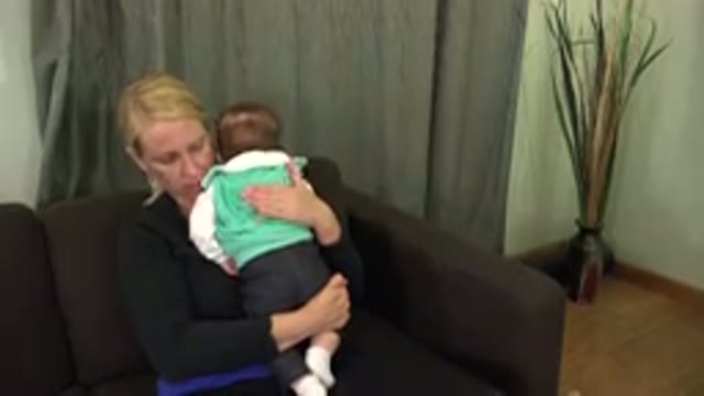WESTMINSTER COLORADO-2015: Mother On Couch Holds Baby Gently And Rocks It To Sleep