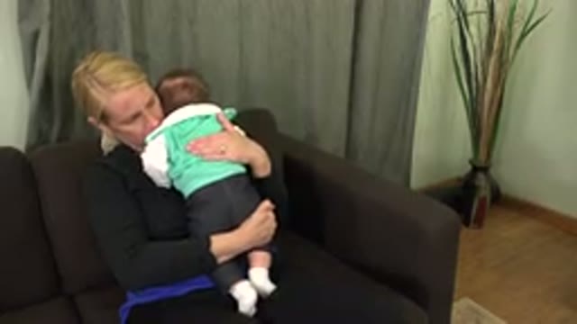 WESTMINSTER COLORADO-2015: Woman Holding A Baby In Her Arm And Trying To Calm It