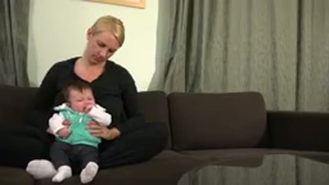 WESTMINSTER COLORADO-2015: Woman Holding a Crying Baby and Sitting on the Sofa